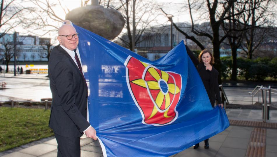 Bilde av byrådsleder og ordfører med kvenfolkets flagg mellom seg