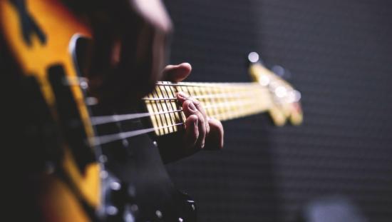 Bildet viser hendene til en som spiller gitar