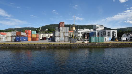Dokken sett fra sjøen. Sjø,kontainere og blå himmel