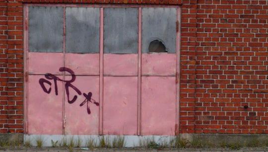 illustrasjonsbilde - teglsteinsvegg med rosa dør