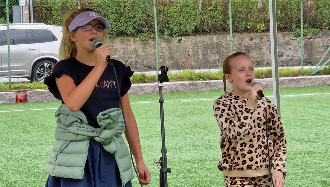 To jenter synger i mikrofon