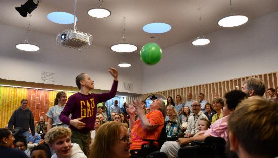 Publikum i sal med ballong som spretter rundt