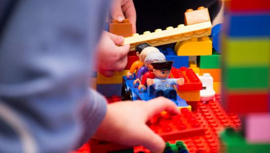 Barnehender som leker med Lego