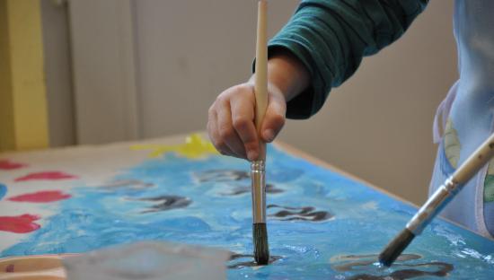Barnehånd som maler med pensel