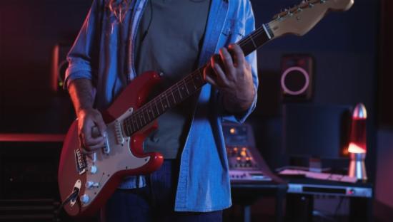 En mann spiller på en elektrisk gitar. 