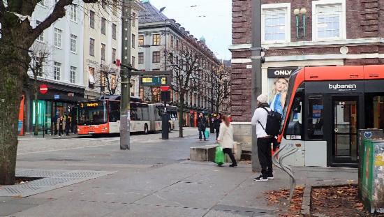 Fotografi fra Byparken mot Olav Kyrres gate. Det er en buss og en bybane med i bildet.