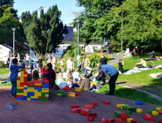 Park med barn som bygger LEGO og folk som slapper av