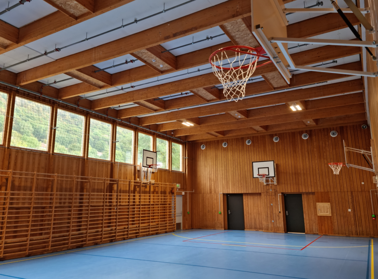 En gymsal med trevegger og basketballkurver