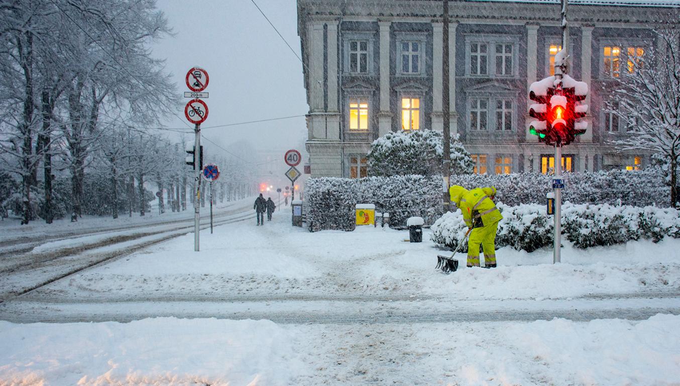 En person måler snø i sentrum
