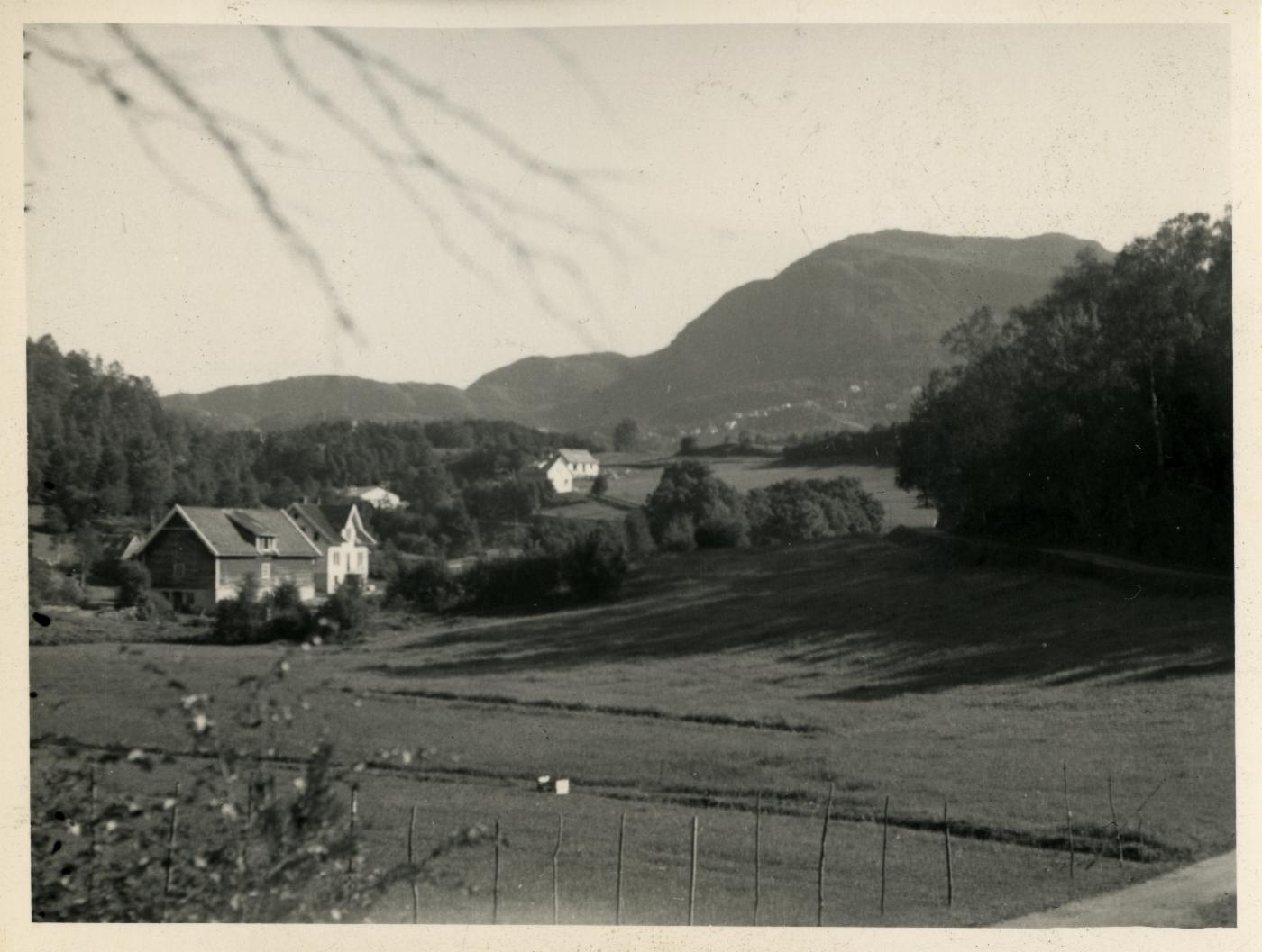 Historisk bilde som viser gård og jorder
