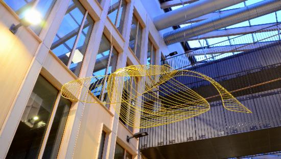 Skulptur i gul streng som henger i Bergen integreringssenter