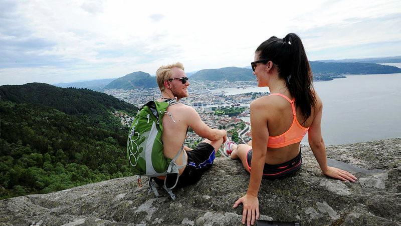 En mann og en dame som sitter på en fjelltopp