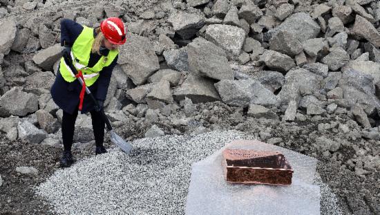 Byråd Marte Monstad graver på en byggeplass for å kunne legge ned grunnstein for Midtbygda behandlingssenter.