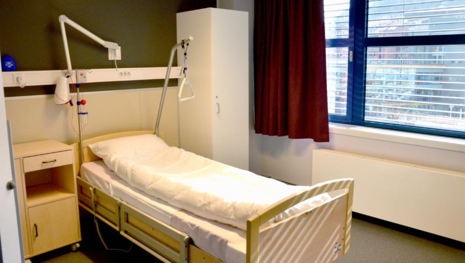 Bildet viser et rom med en seng på institusjon.