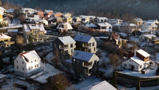 Bilde av tre nye boliger med saltak i et eksisterende boligområde.
