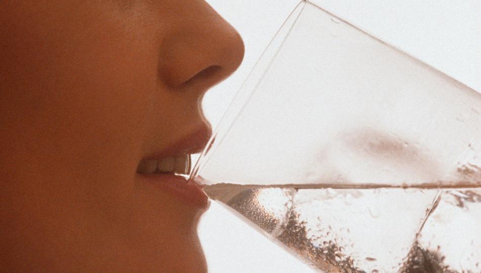 Drikker vann fra glass